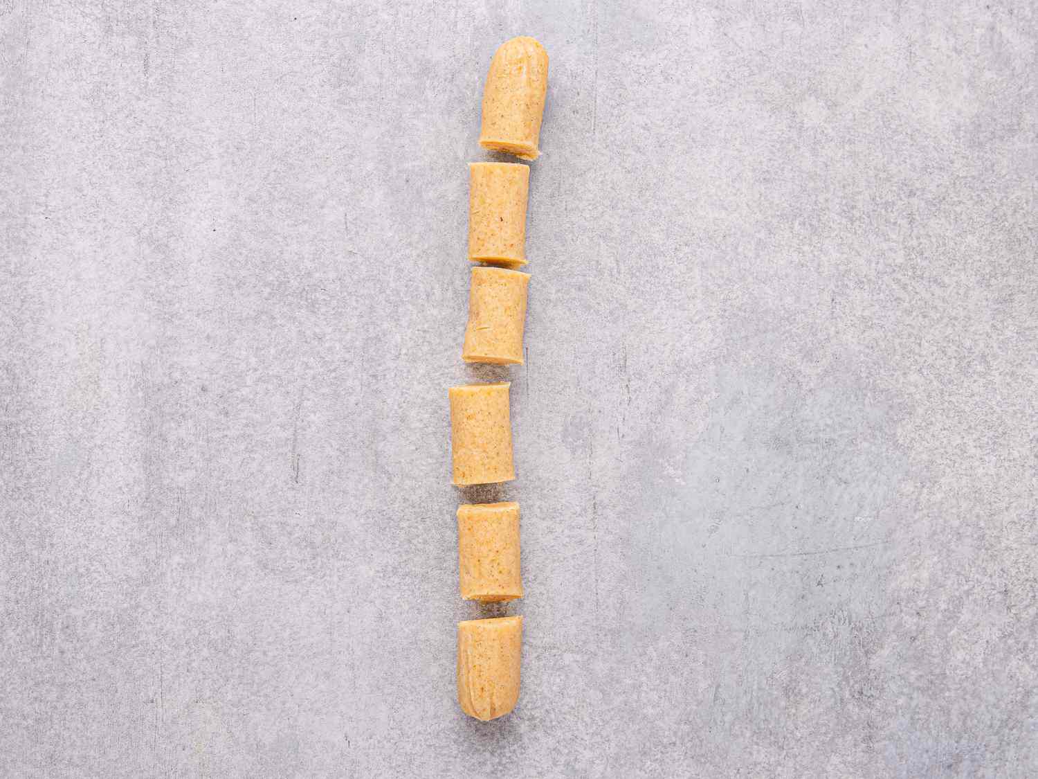 Segments of rolled dough positioned on a flat surface possibly for baking preparation