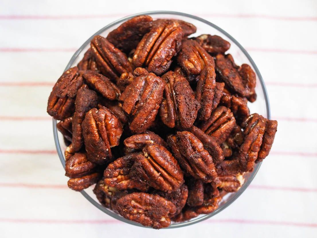 A glass bowl of homemade Mexican spiced chocolate pecans. 