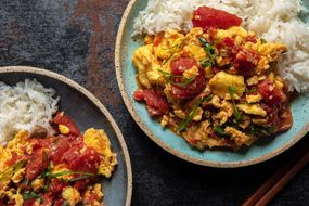 Two plated dishes of tomato and egg with rice.