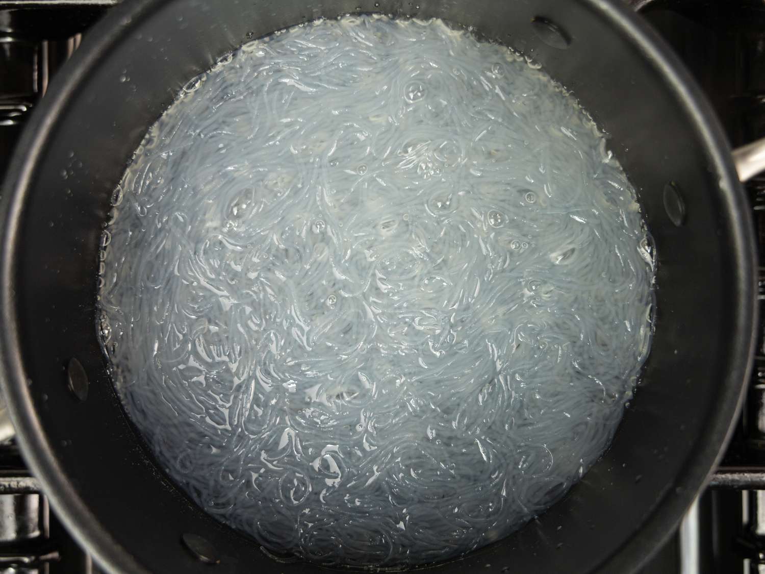 Overhead view of noodles boiling in pot