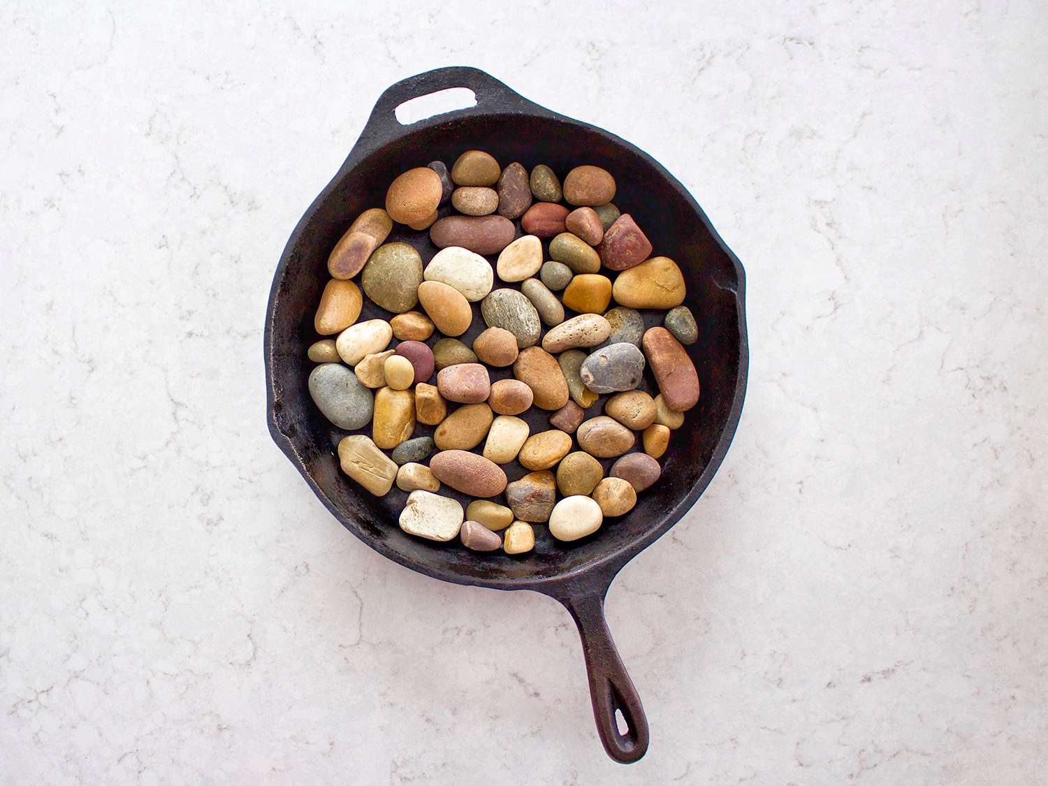River rocks line a cast-iron pan.
