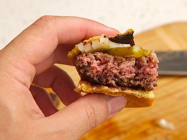 Author holding the last remaining portion of a mostly devoured burger.