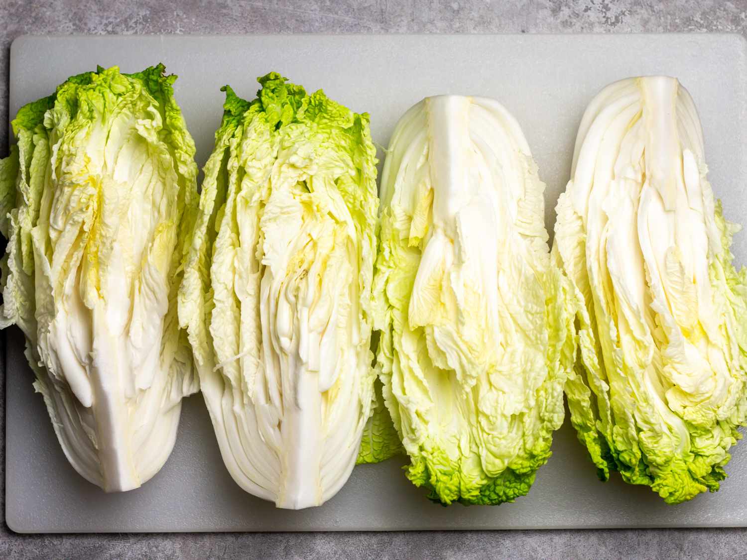 a head of napa cabbage cut into 4 quarters in preparation for baechu kimchi