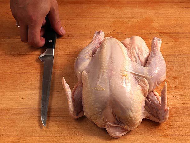 Sharp knife in hand ready to bone whole turkey