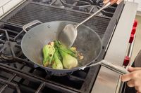Bok choi is cooked in the Misen 12 Inch Carbon Steel Wok