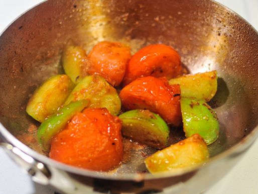 Tomatillos and tomatoes cooking in a pot.