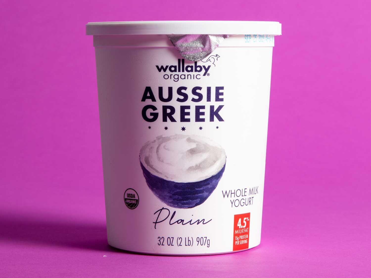 A 32-ounce tub of Wallaby Aussie Whole Milk Plain Greek Yogurt against a pink background.