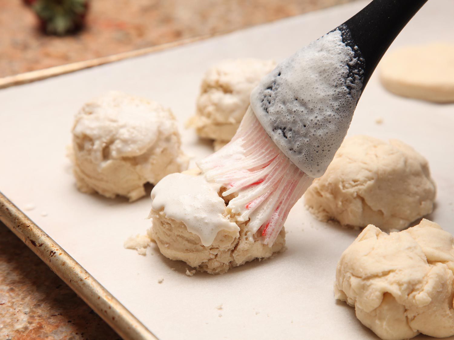 Brushing cream over two-ingredient biscuits. 