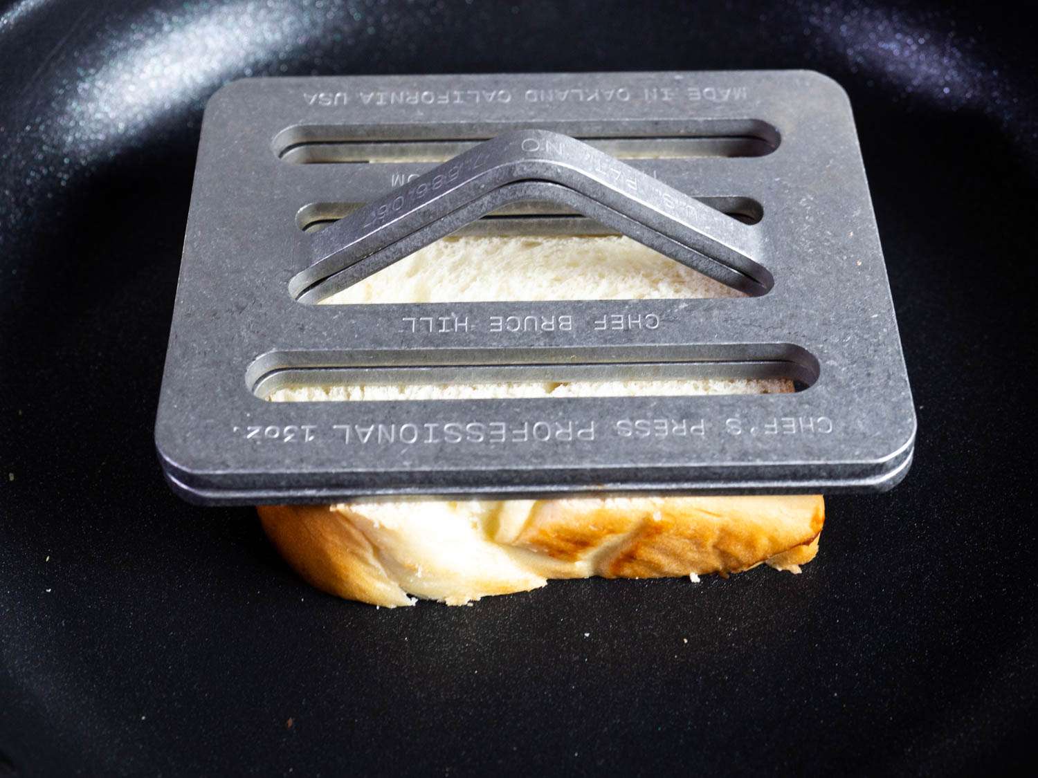 Cooking weights help a piece of toast brown evenly in the skillet