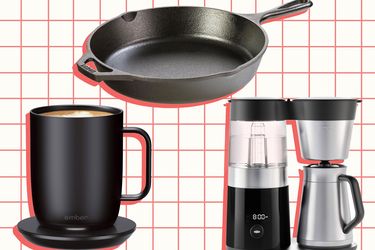 A black mug with a warmer, a cast iron skillet, and a compact coffee maker with components