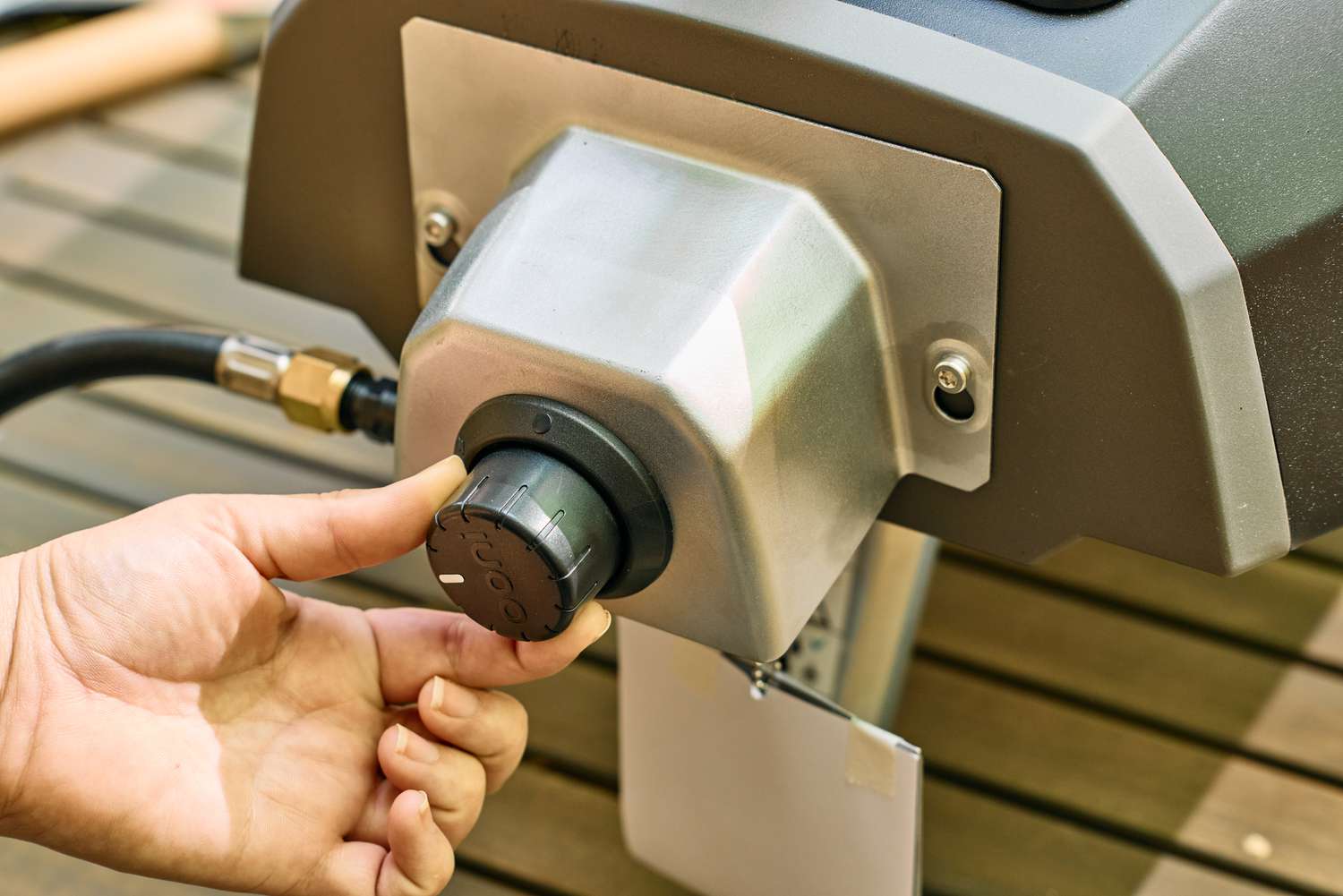 A person turns a dial on the Ooni Karu 2 Multi-Fuel Pizza Oven