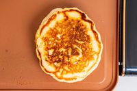 A closeup of a pancake cooking on the Crux electric griddle