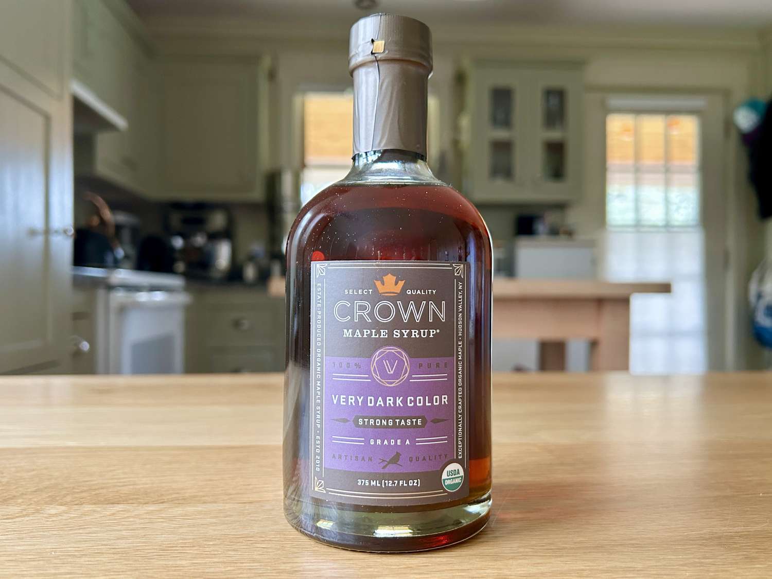 A bottle of Crown maple syrup on a kitchen table