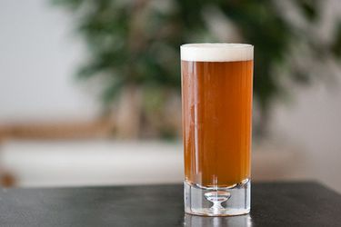 A glass of American Pale Ale on a counter top. 