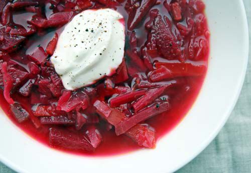 A bowl of vegetarian borscht with a dollop of sour cream on top. 