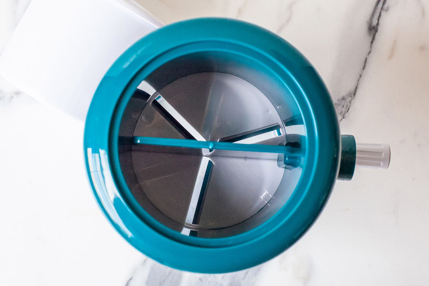 Closeup of MANBA Ice Shaver and Snow Cone Machine with internal spokes on a white surface
