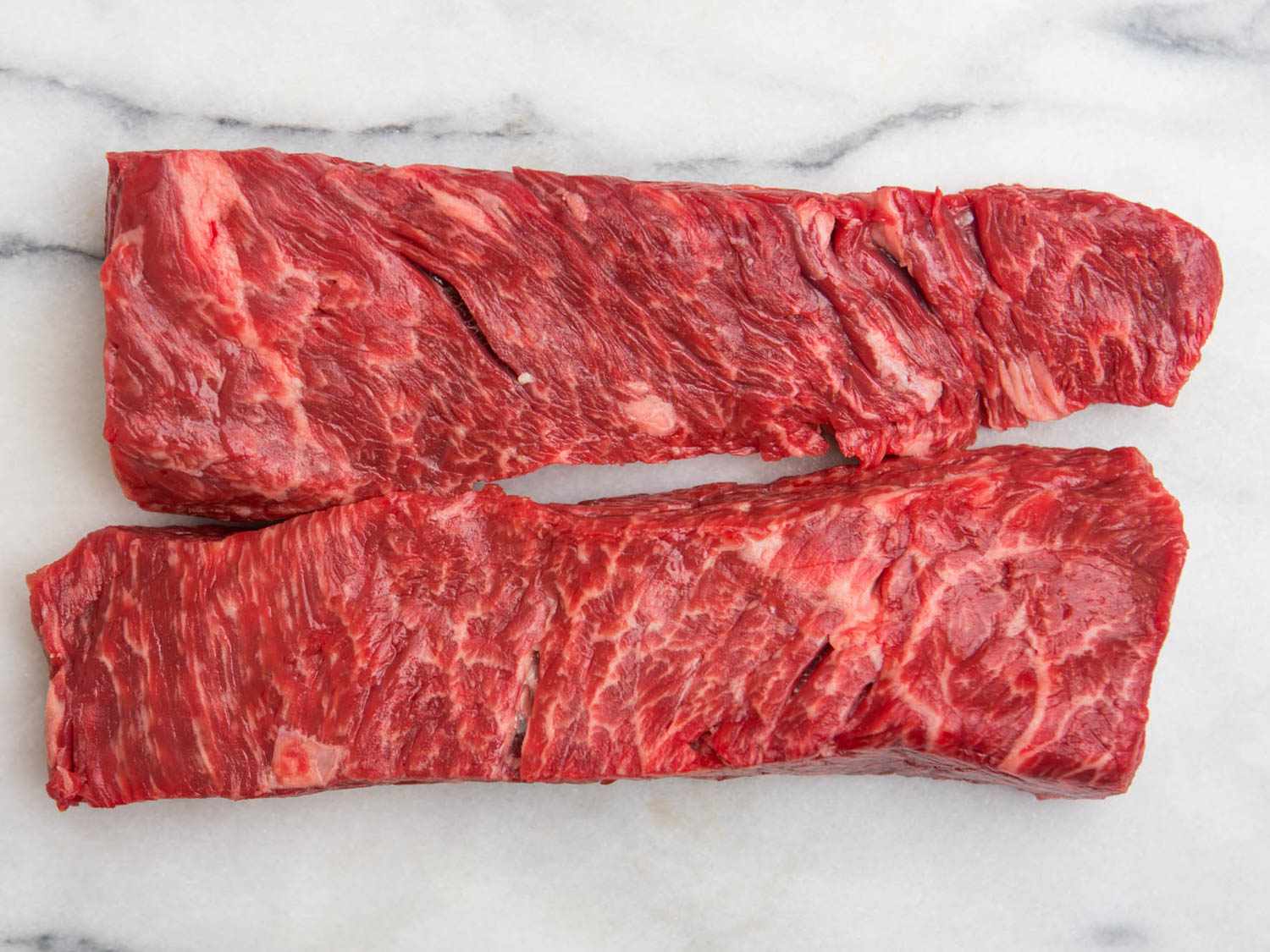Two pieces of Bohemian cut or bottom sirloin flap meat on marble surface