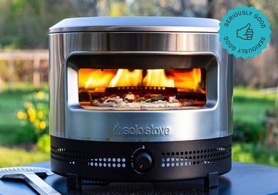 the solo stove pizza oven with a pizza baking inside