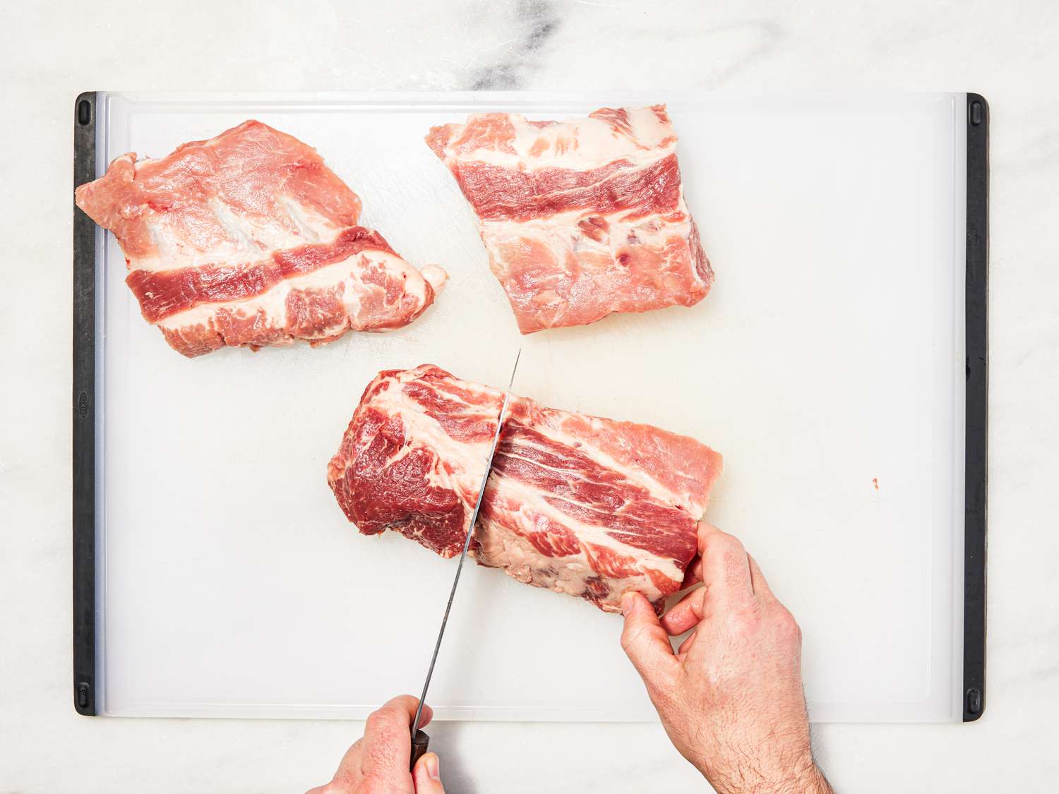 Overhead view of splitting ribs on a cutting board.