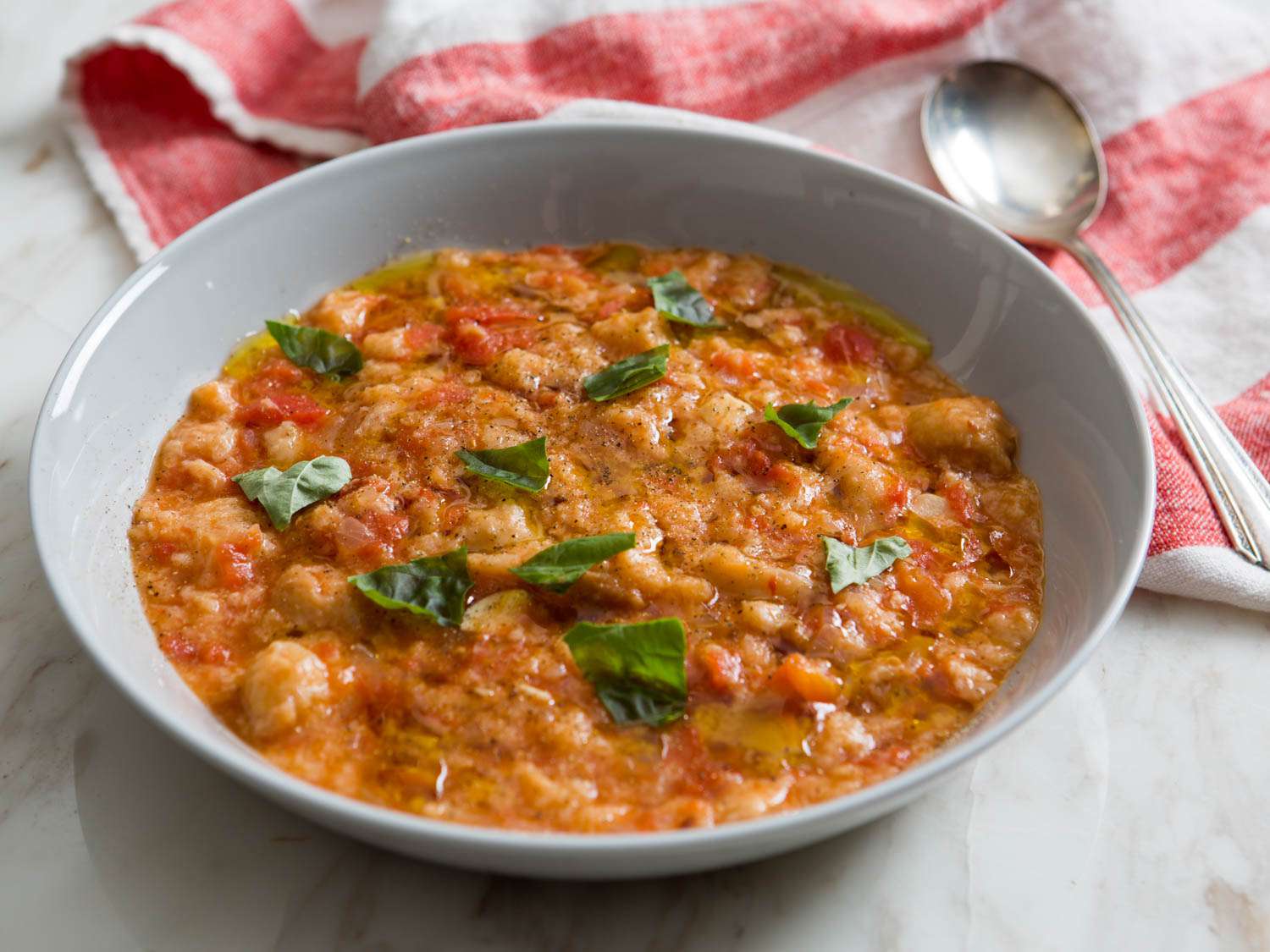 A bowl of the finished pappa al pomodoro, garnshied with torn basil leaves.