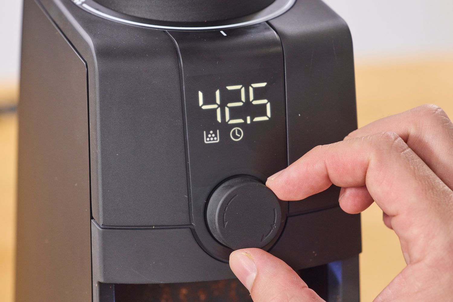 A person adjusts the knob on the Baratza Encore ESP Pro Coffee Grinder with a digital display
