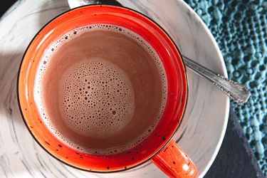 Overhead shot of a red mug containing hot chocolate.