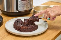 A person cuts cake baked in the Instant Pot Duo Plus 6-Quart 9-in-1 Pressure Cooker