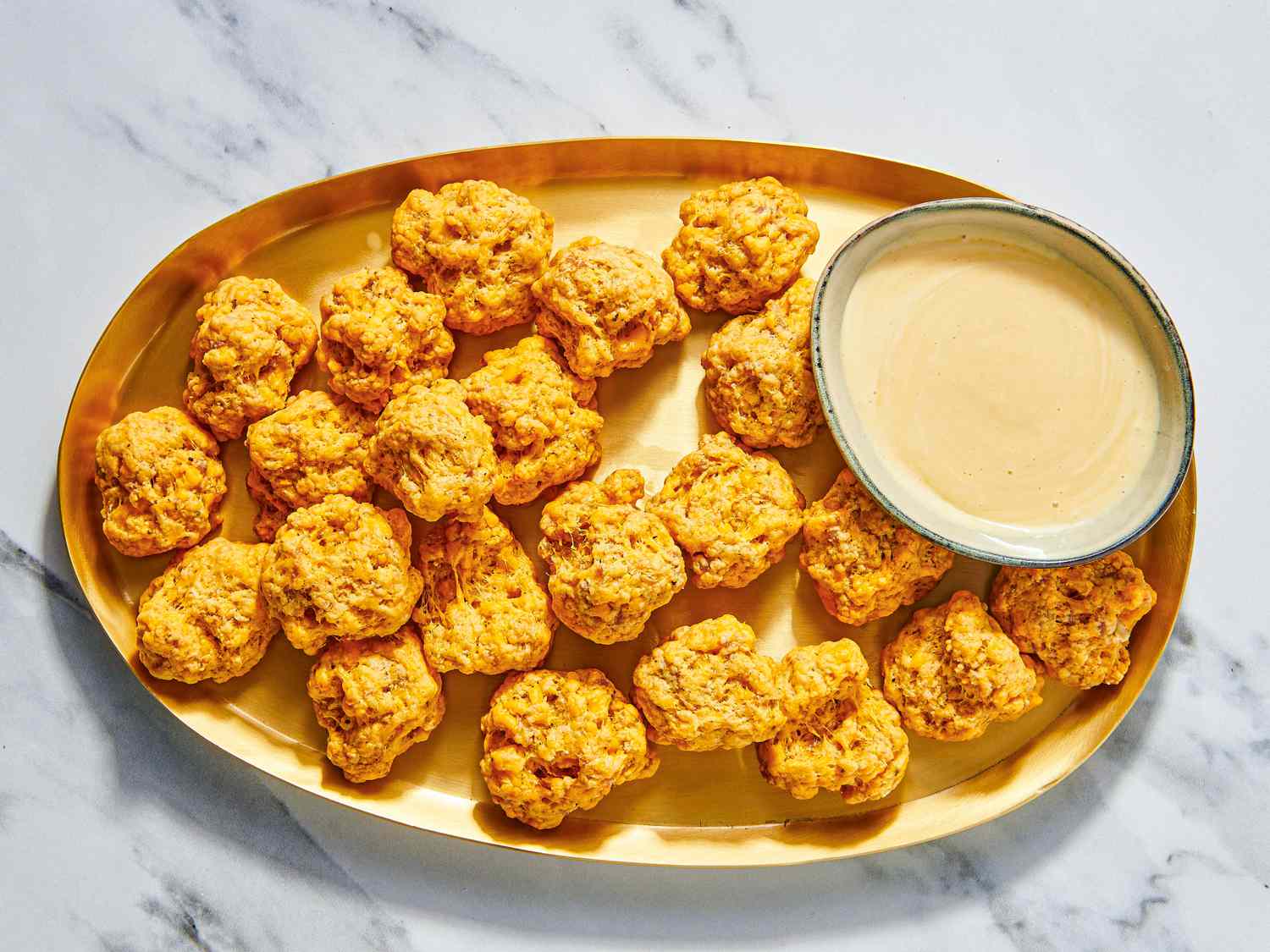 Overhead of sausage balls on a plate with sauce