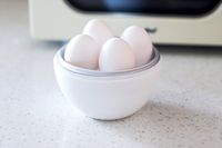 Four eggs in the Nordic Ware Egg Boiler in front of a microwave