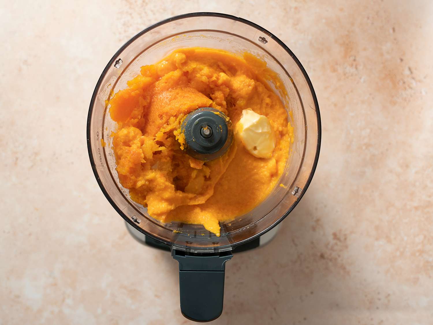 Butternut squash, cream, and butter being purÃ©ed in a food processor.