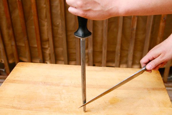 The blade has been swept toward the bottom of the steel, touching it at the tip of the blade.