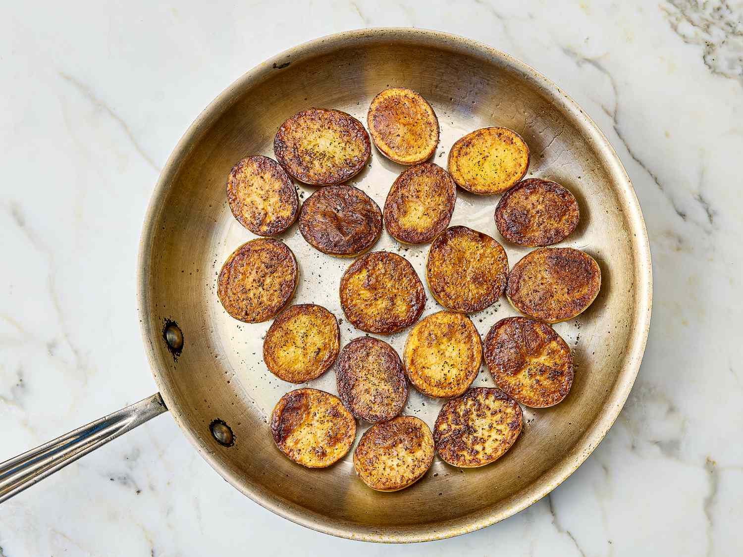 Rounds of roasted potatoes in a pan