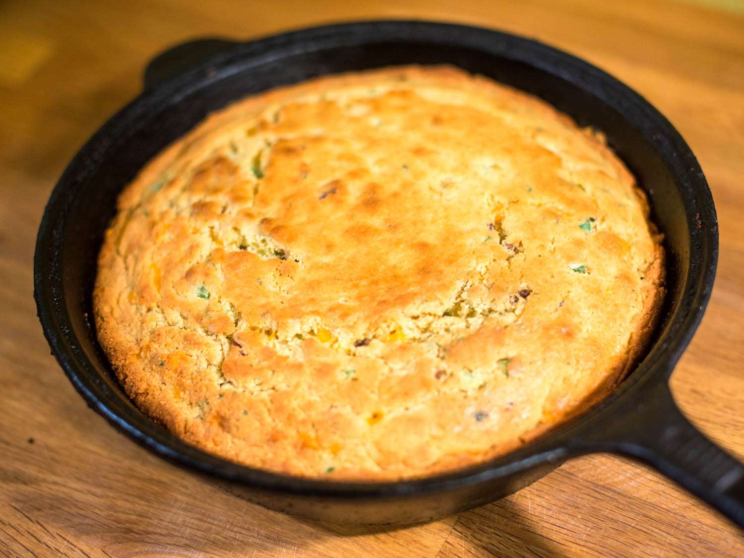 Cheddar, bacon, and scallion cornbread baked in cast-iron skillet.