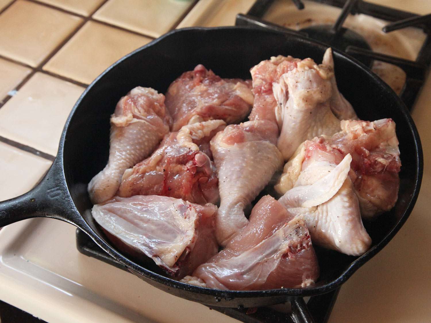 Chicken pieces searching skin side-down in a skillet
