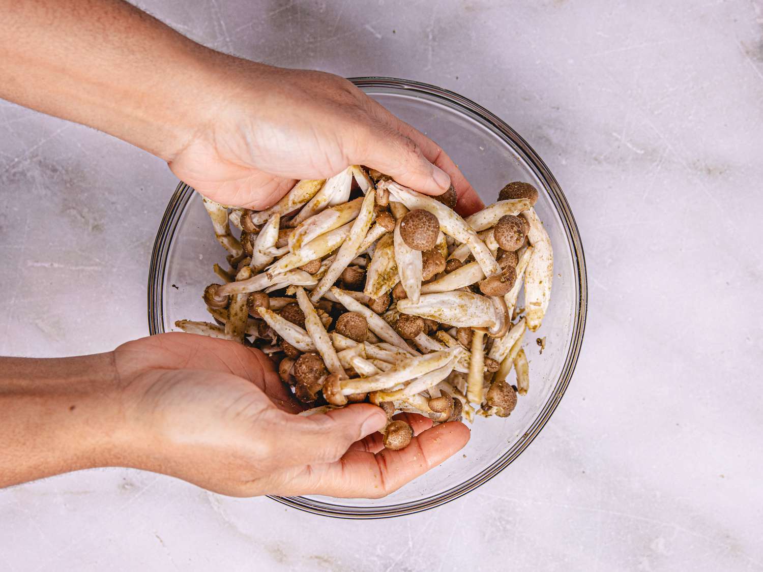 Hands mixing vegetables in a bowl