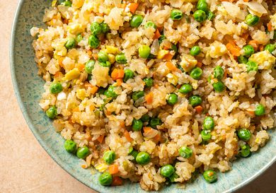 Vegetable fried rice inside a green ceramic bowl.