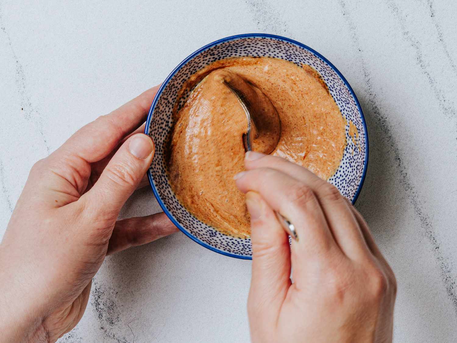 Overhead view of mixing dipping sauce for Tostones