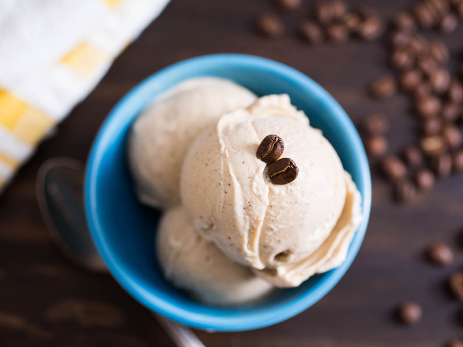 A dish holding three scoop of milky and mild coffee ice cream.