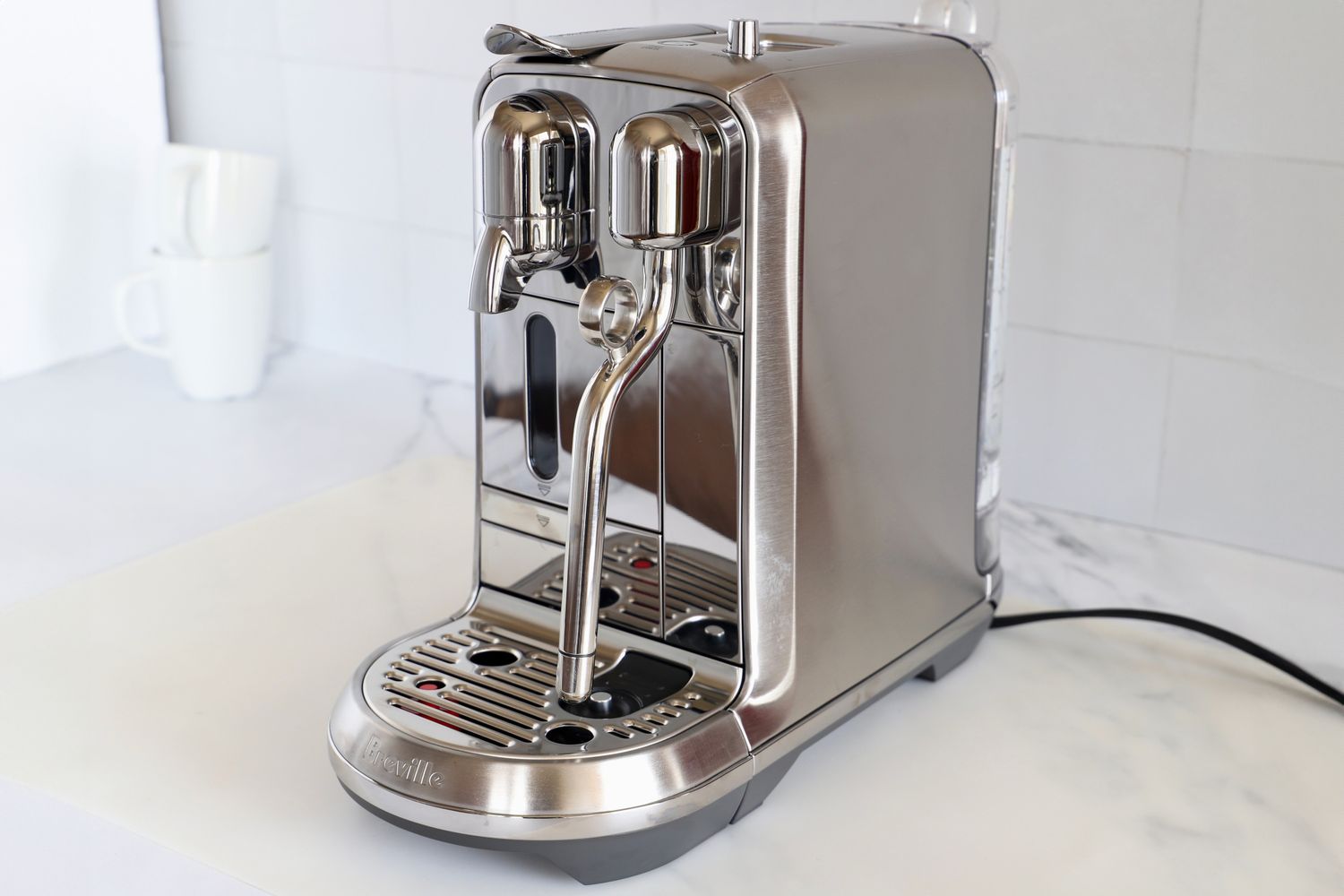 A stainless steel espresso machine with dual spouts and a milk frother