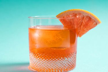 An Unusual Negroni in a rocks glass with a grapefruit wedge on the rim. 