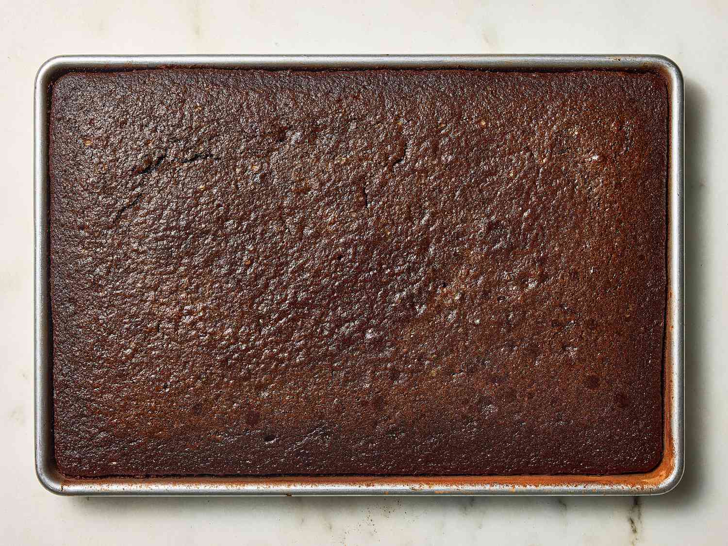 chocolate cake cooling on white marble surface 