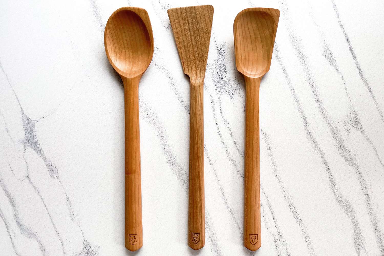 Field Company Cherry Wood Spoons & Spatulas on a white marble surface