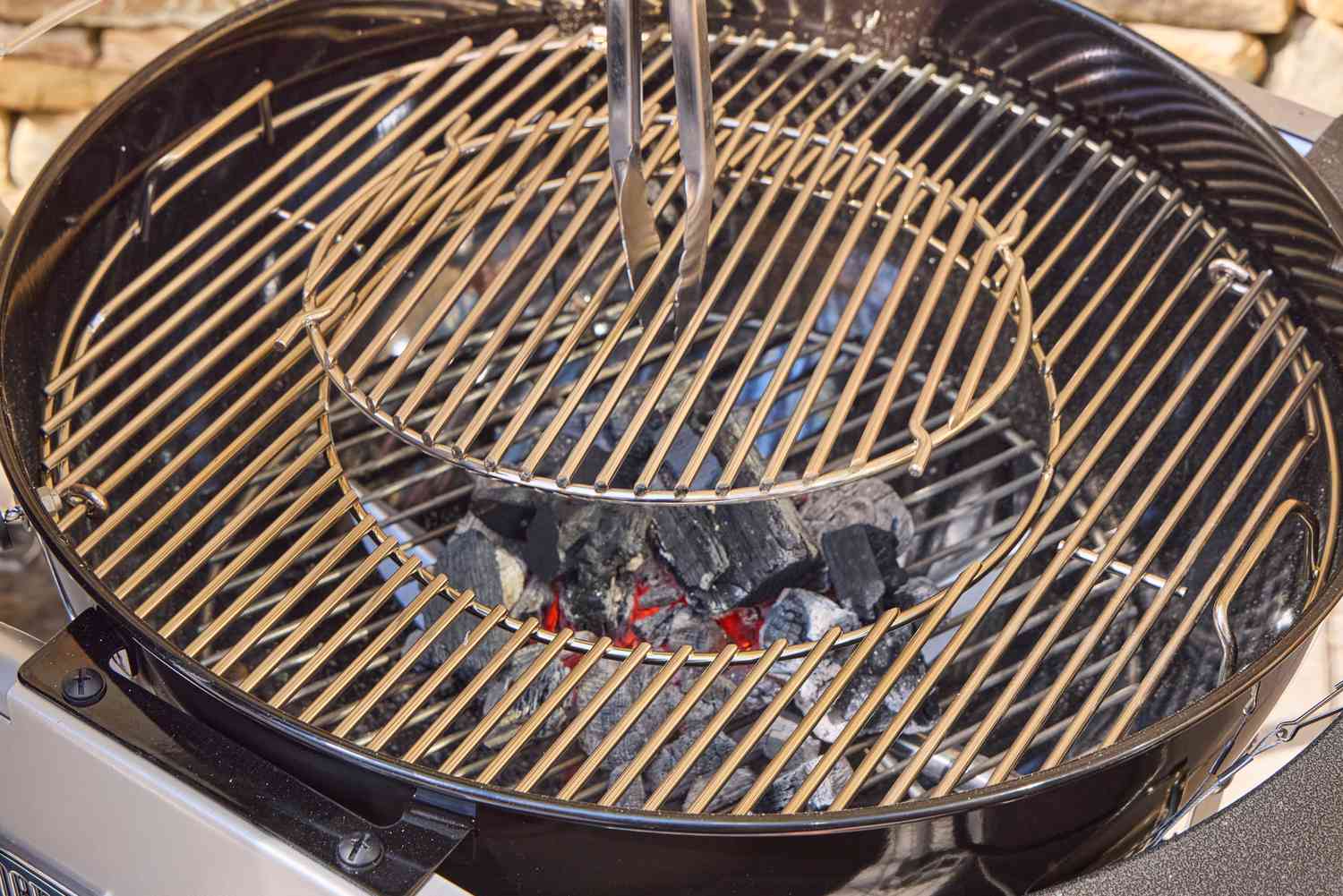 Tongs touching the Weber Performer Deluxe Charcoal Grill 22