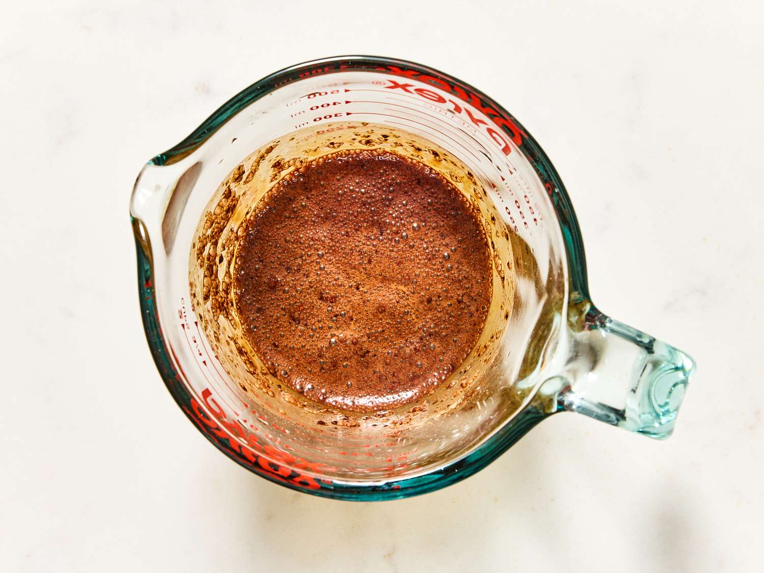 A glass measuring cup containing blended ingredients for a mocha frapp