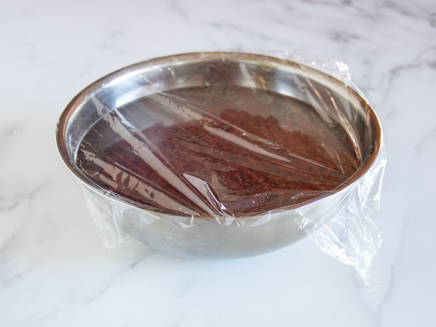 Beans soaking in a silver bowl.
