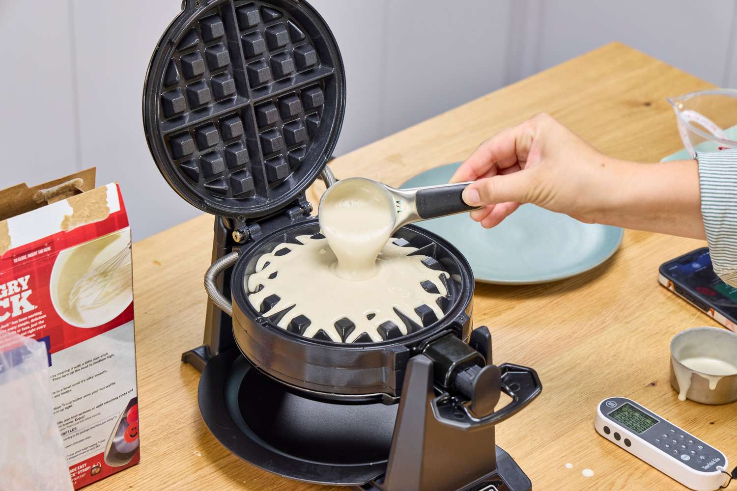 A person pours batter into the Black+Decker Double Flip Rotating Waffle Maker