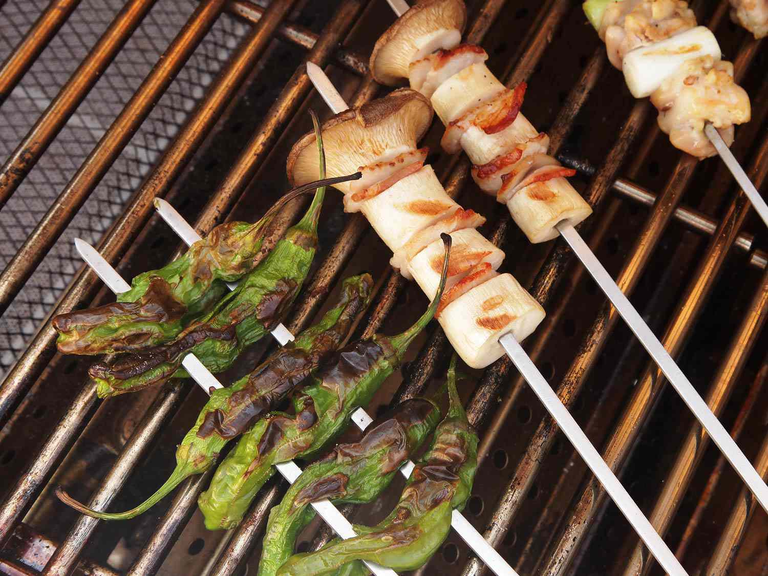 Peppers and mushrooms on skewers on the grill.