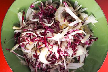 Overhead view of Fennel and Radicchio Salad With Tangerine Vinaigrette, served in a green bowl.