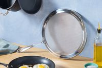 the all-clad splatter screen resting on a blue backdrop