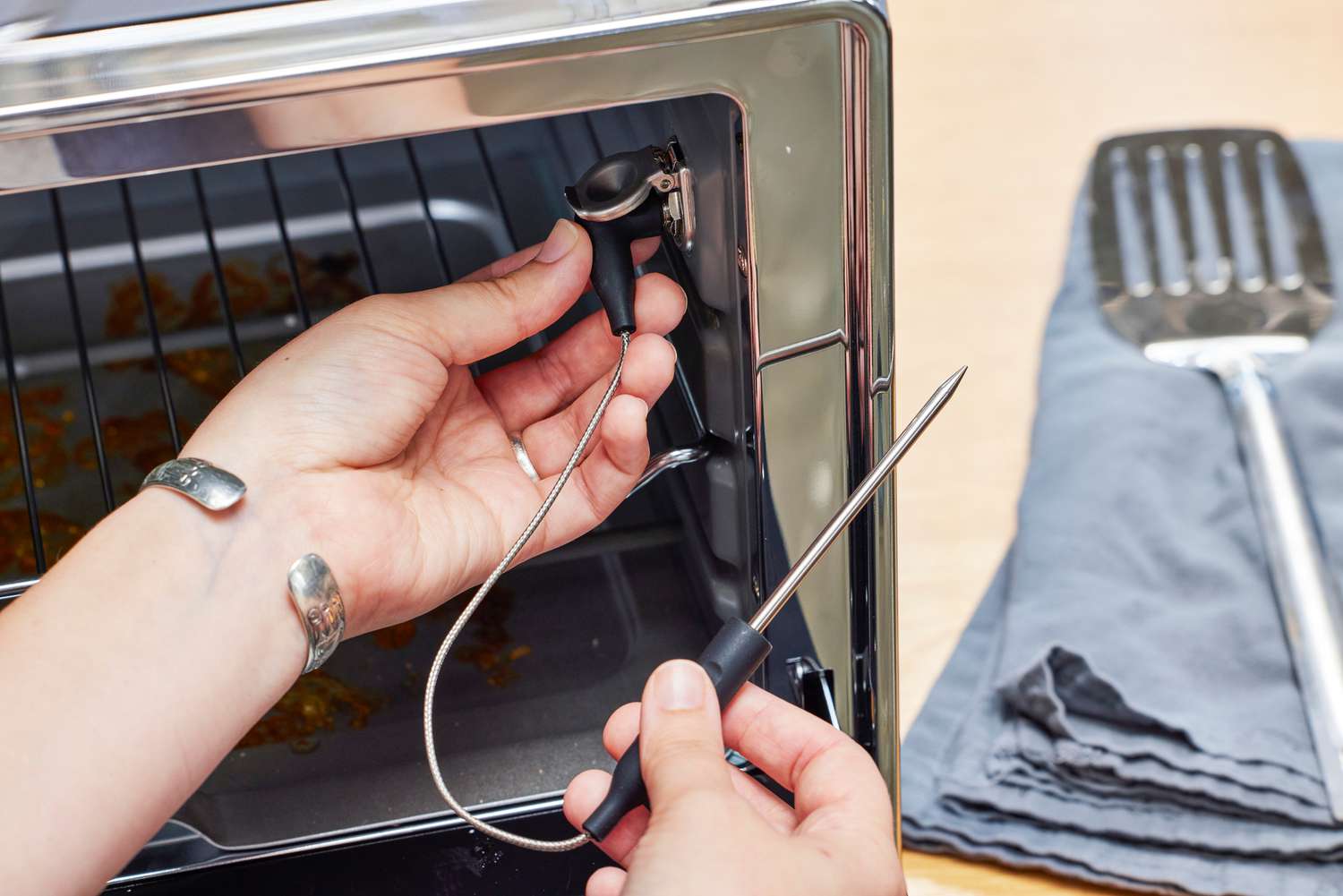 A person placing a device into the KitchenAid Dual Convection Countertop Oven with Air Fryer